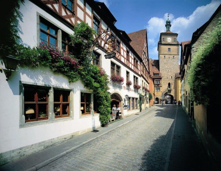Georgengasse mit Fachwerkhäusern, Blumenranken und Blick zum Weißen Turm