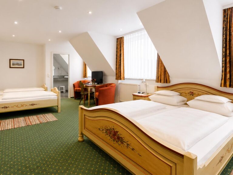 Quadruple Room under the sloping ceiling with a painted double bed and green rug