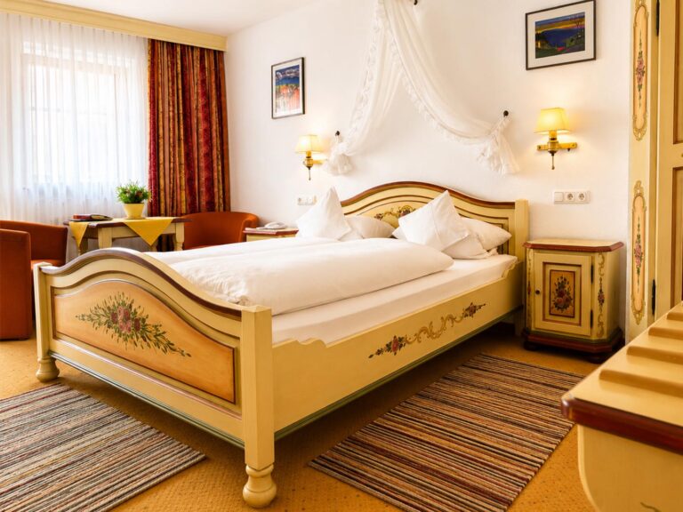 Comfort Double Room with a cream-coloured painted double bed and a light canopy